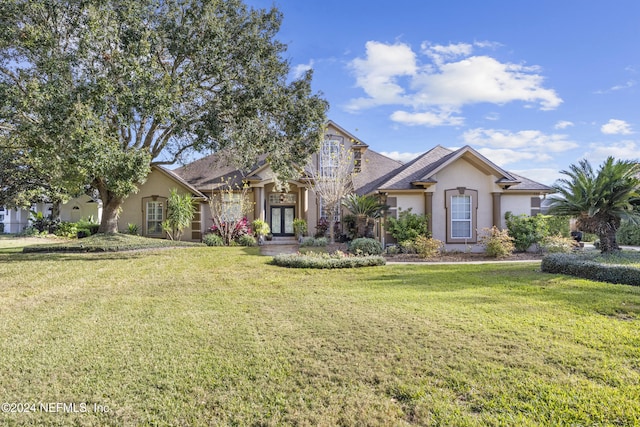 view of front facade with french doors and a front lawn