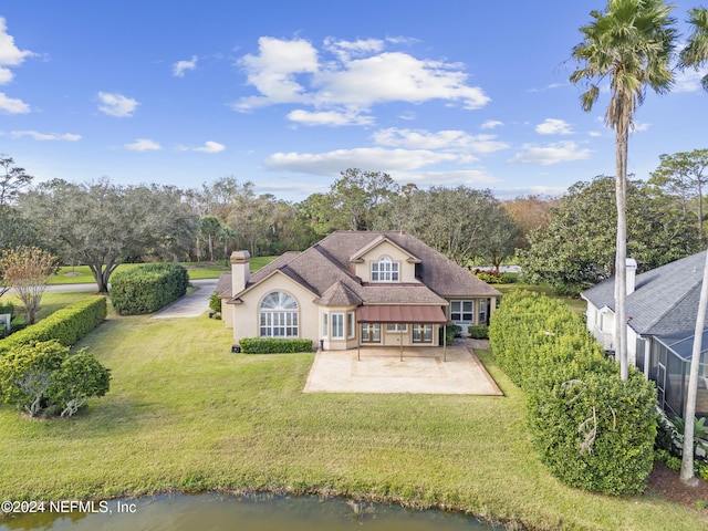 back of house with a yard and a water view