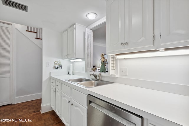 kitchen with dark parquet flooring, white cabinetry, sink, stainless steel dishwasher, and ornamental molding