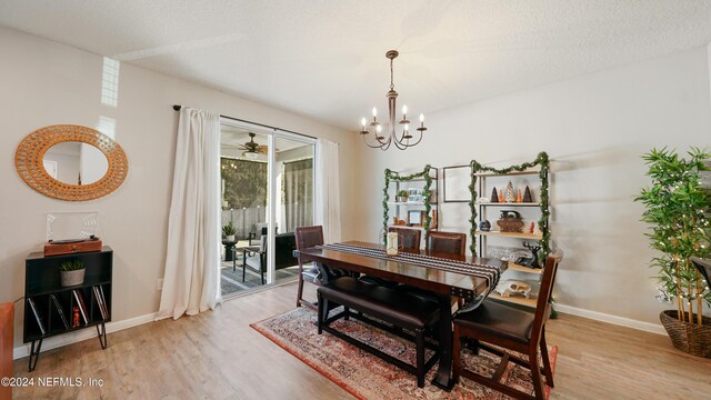 dining area with ceiling fan with notable chandelier, a textured ceiling, and light wood-type flooring