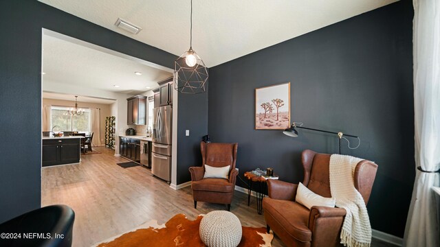 living area featuring a chandelier and light wood-type flooring