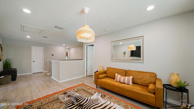 living room featuring light hardwood / wood-style floors and a textured ceiling