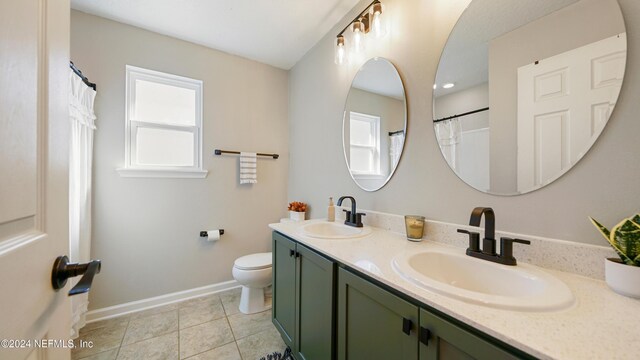 bathroom featuring tile patterned flooring, vanity, and toilet