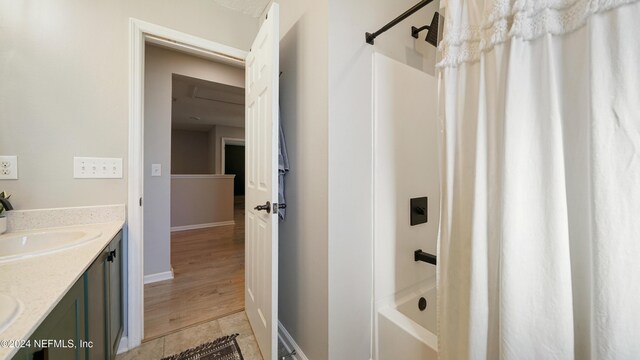 bathroom featuring hardwood / wood-style floors, vanity, and shower / tub combo