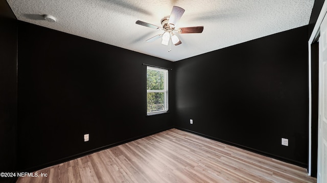 empty room featuring ceiling fan, a textured ceiling, and light wood-type flooring