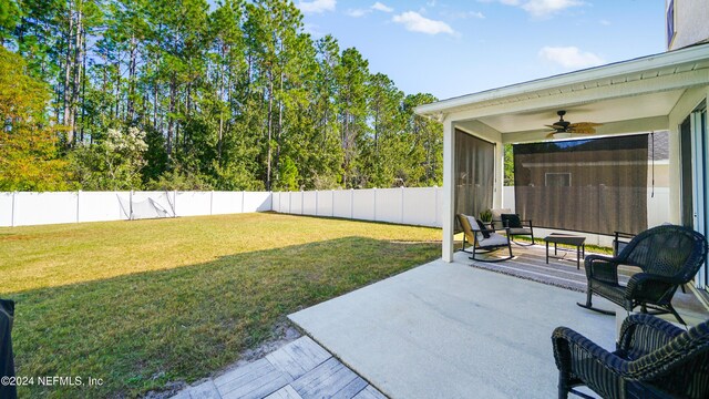 view of yard with ceiling fan and a patio area