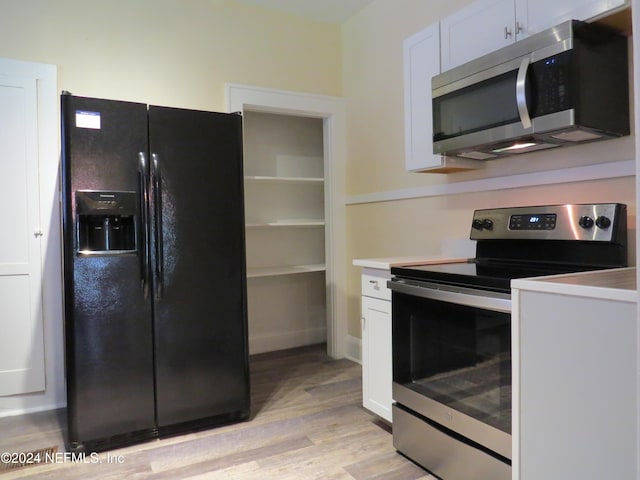 kitchen with light wood-type flooring, white cabinetry, and stainless steel appliances