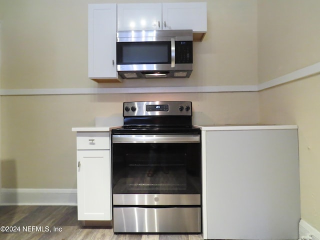 kitchen featuring white cabinetry, hardwood / wood-style floors, and stainless steel appliances