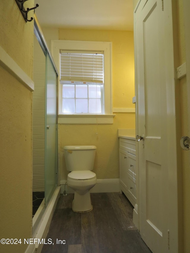 bathroom featuring hardwood / wood-style floors, vanity, an enclosed shower, and toilet