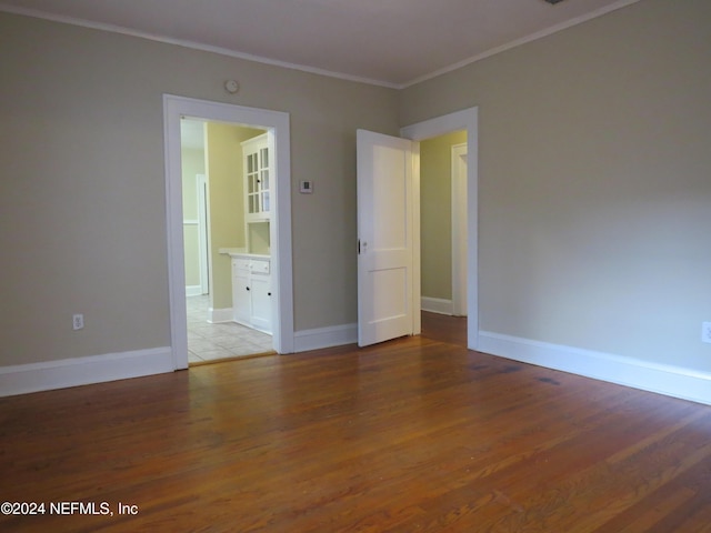 empty room with crown molding and hardwood / wood-style floors