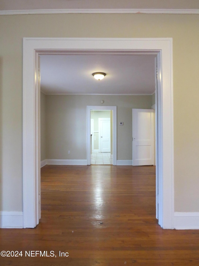 hallway featuring crown molding and dark wood-type flooring