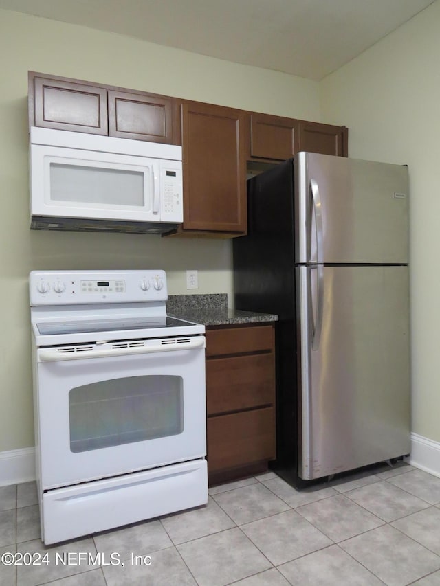 kitchen featuring light tile patterned floors and white appliances