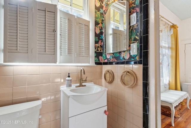 bathroom featuring tile walls, toilet, and vanity