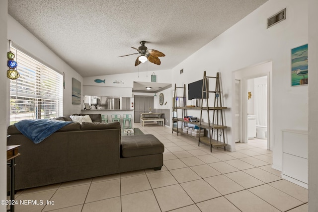 living room featuring a textured ceiling, ceiling fan, and light tile patterned flooring