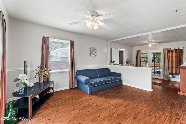 interior space featuring a textured ceiling, ceiling fan, and dark wood-type flooring