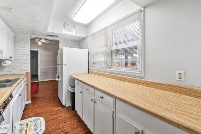 kitchen featuring ceiling fan, dishwasher, dark hardwood / wood-style flooring, white refrigerator, and white cabinets