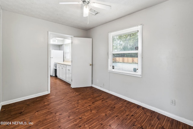 empty room with a textured ceiling, dark hardwood / wood-style floors, and ceiling fan