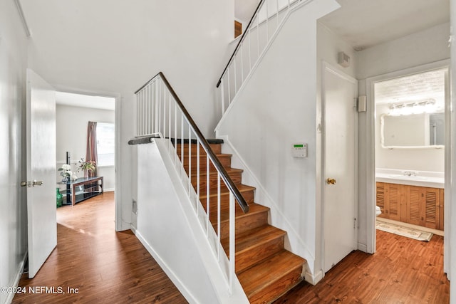 stairway featuring hardwood / wood-style floors and sink