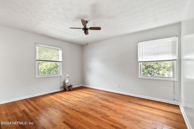 empty room featuring a textured ceiling, light hardwood / wood-style flooring, and ceiling fan