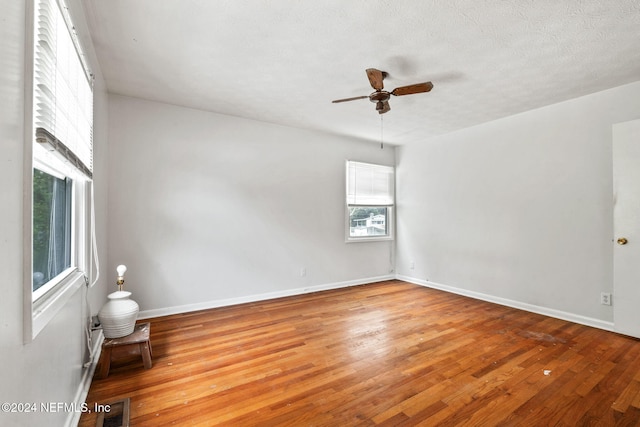 spare room featuring hardwood / wood-style floors, ceiling fan, and a textured ceiling