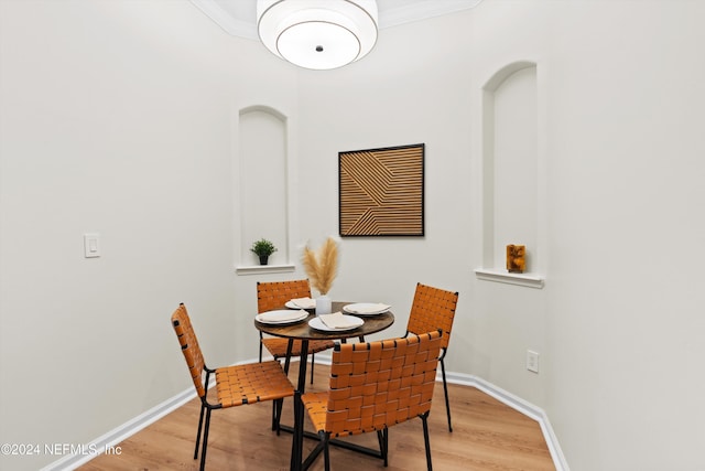 dining space featuring ornamental molding and light hardwood / wood-style flooring