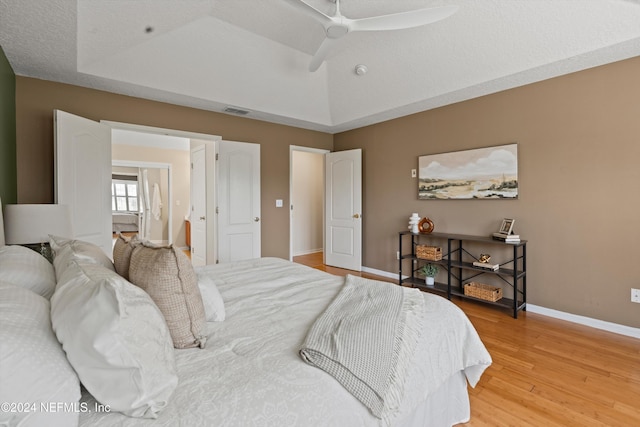 bedroom with wood-type flooring, a textured ceiling, ceiling fan, and lofted ceiling