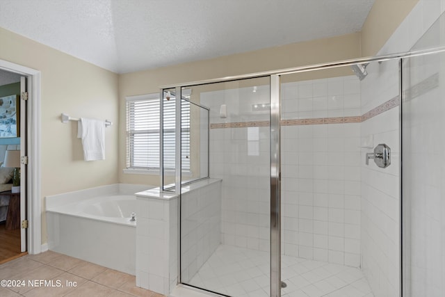 bathroom featuring tile patterned flooring, shower with separate bathtub, and a textured ceiling