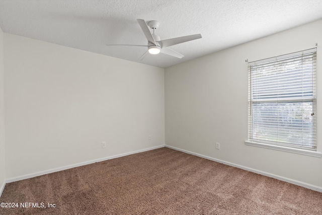 unfurnished room with carpet, ceiling fan, and a textured ceiling