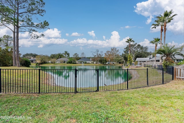 view of pool with a water view and a lawn