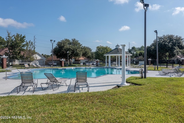 view of swimming pool featuring a lawn, a patio area, and a gazebo