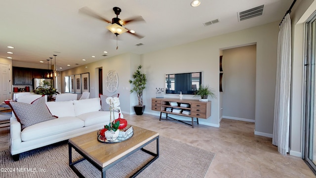 living room featuring ceiling fan with notable chandelier