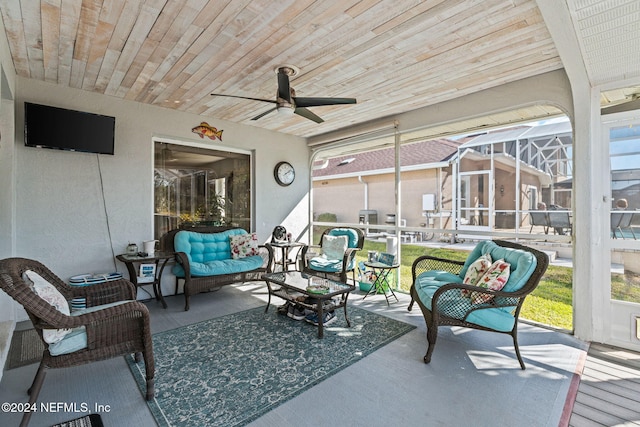 sunroom with ceiling fan, a healthy amount of sunlight, and wood ceiling