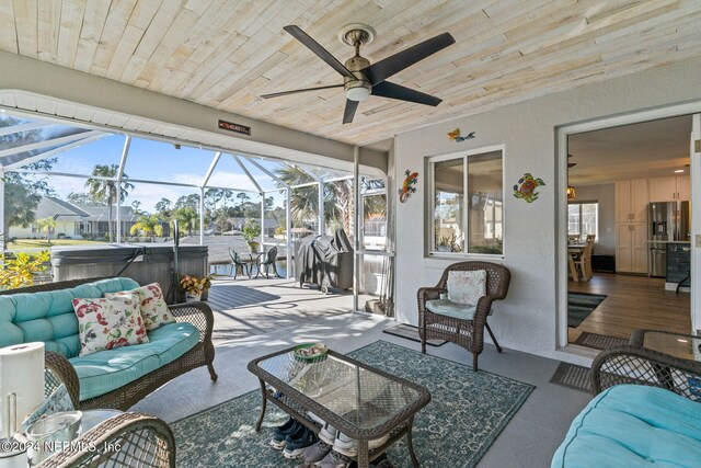 sunroom / solarium with ceiling fan, plenty of natural light, and wooden ceiling