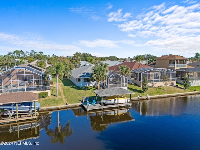 exterior space with a water view, a lanai, and a lawn