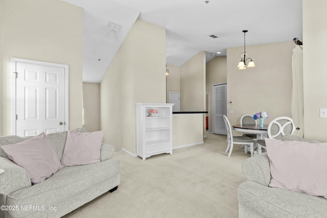 living room with an inviting chandelier, high vaulted ceiling, and light colored carpet