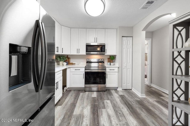 kitchen featuring white cabinetry, hardwood / wood-style flooring, and appliances with stainless steel finishes