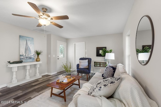 living room featuring ceiling fan and dark wood-type flooring