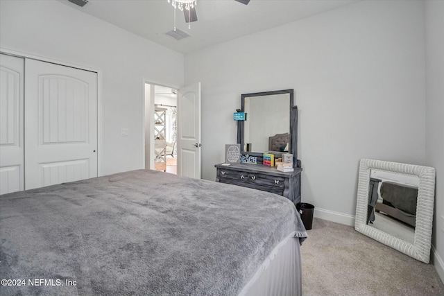 bedroom with ceiling fan, a closet, and light carpet