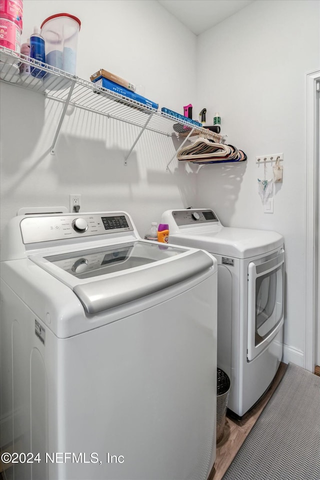 washroom featuring dark hardwood / wood-style floors and washing machine and clothes dryer