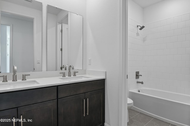 full bath with double vanity, a sink, toilet, and shower / bathtub combination