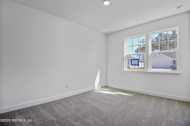 carpeted empty room with a textured ceiling and baseboards