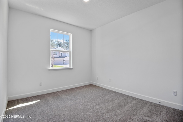 empty room with carpet and baseboards