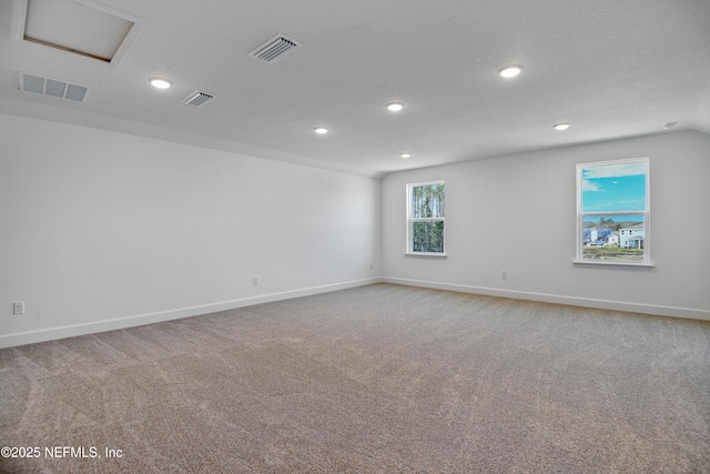 spare room featuring visible vents, carpet, and attic access