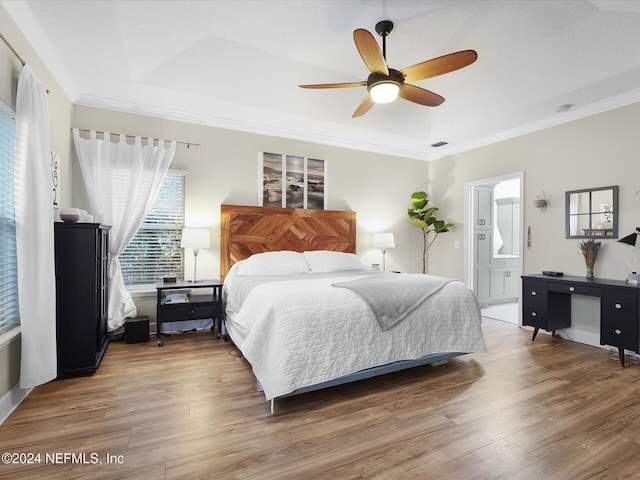 bedroom featuring hardwood / wood-style flooring, ensuite bath, ceiling fan, and crown molding