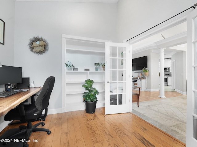 office space with french doors, light hardwood / wood-style floors, and ornate columns