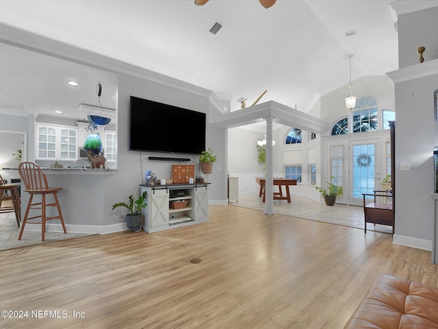 living room featuring crown molding, light hardwood / wood-style flooring, a healthy amount of sunlight, and ceiling fan with notable chandelier