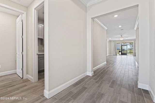 corridor featuring ornamental molding and hardwood / wood-style flooring