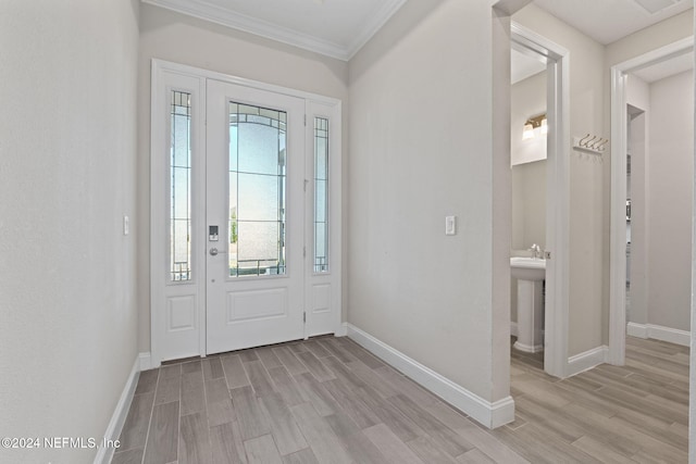 foyer featuring sink, crown molding, and light hardwood / wood-style flooring