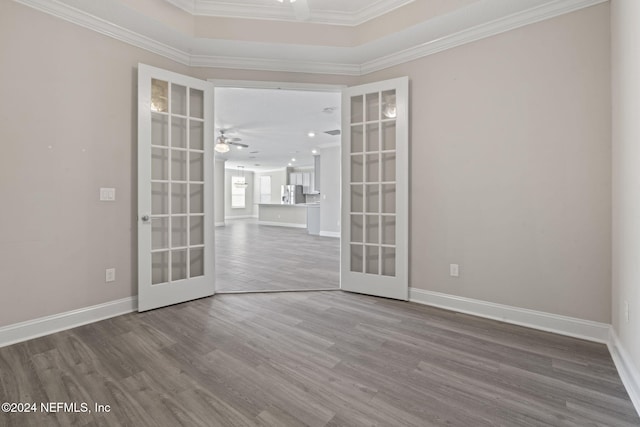 empty room with french doors, hardwood / wood-style flooring, ceiling fan, and crown molding