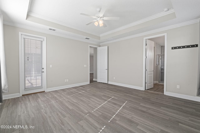 unfurnished room featuring a tray ceiling, crown molding, and hardwood / wood-style flooring